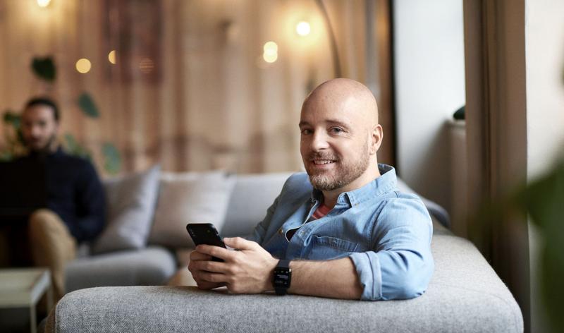 man in blue shirt holding mobile phone